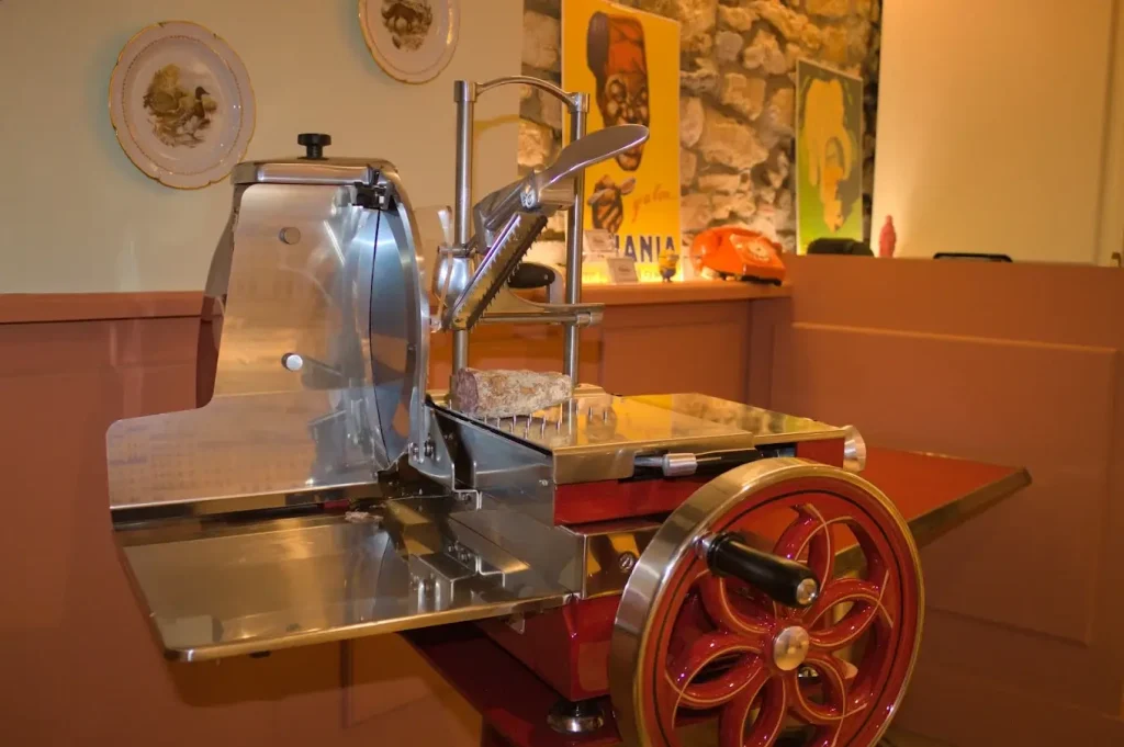 Trancheuse à charcuterie artisanale Maison Roussey au Bistrot Marie – machine manuelle vintage rouge et chrome