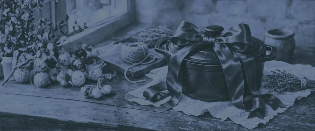 Carte cadeau du Bistrot Marie – cocotte en fonte avec ruban cadeau sur une table en bois
