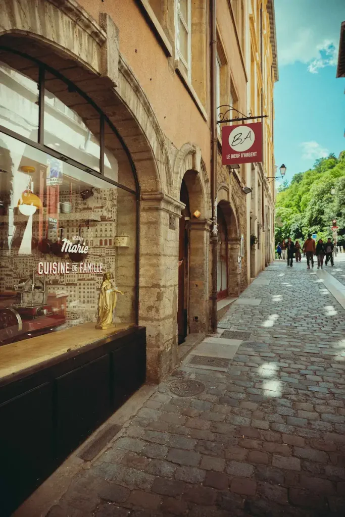 Façade du Bistrot Marie Cuisine de Famille sur la rue du Bœuf pavée et ensoleillée du Vieux-Lyon, Lyon 5